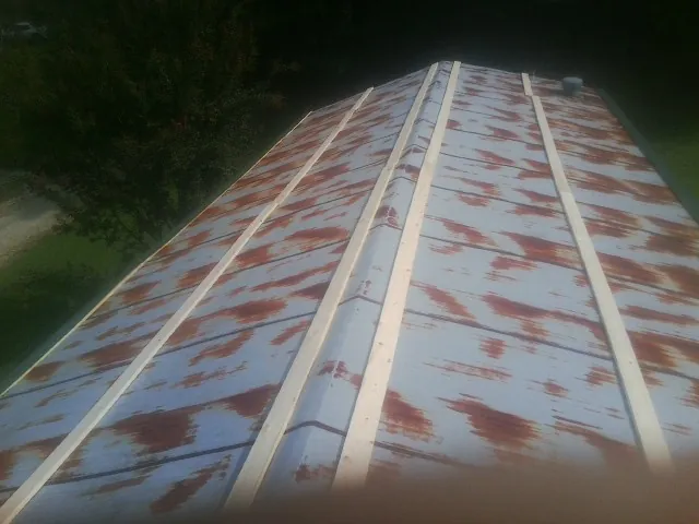 Rusted metal roof panels with new wood purlins before replacement — Storm Damage Roof Repair in Winder by Roofing Brothers