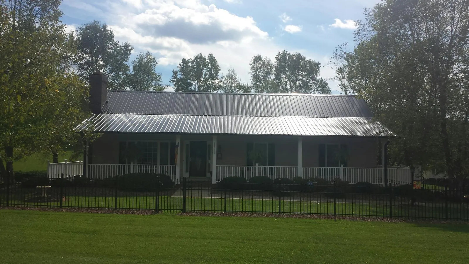 Gray metal roof on a brick ranch with a full width front porch — Gutter Guard Installation work by our crew in Winder