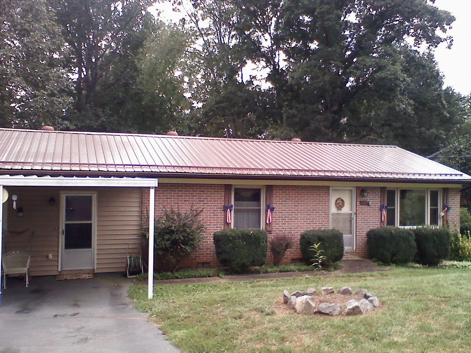 Bronze metal roof and carport on a brick ranch home — Roof Repair work by our crew in Winder