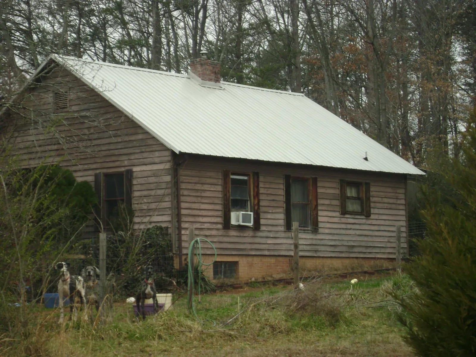 White metal roof on an old wood sided farmhouse, from a Metal Roof Installation job in Winder